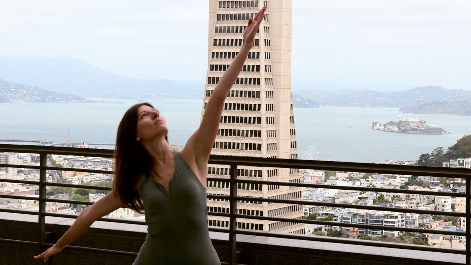 A person doing yoga on a rooftop with the city in the background