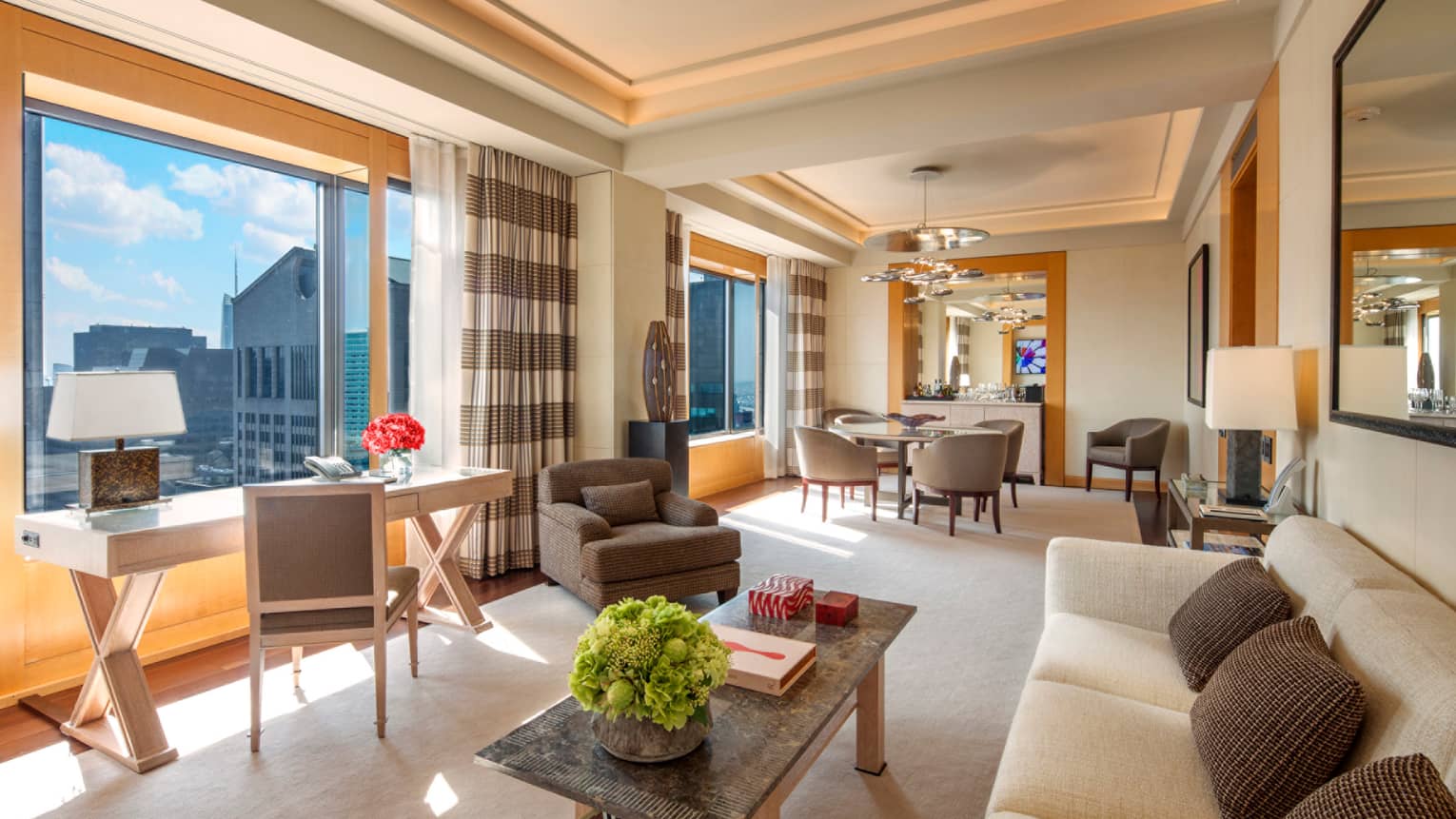 Manhattan Suite desk under sunny window, white sofa, dining table by bar