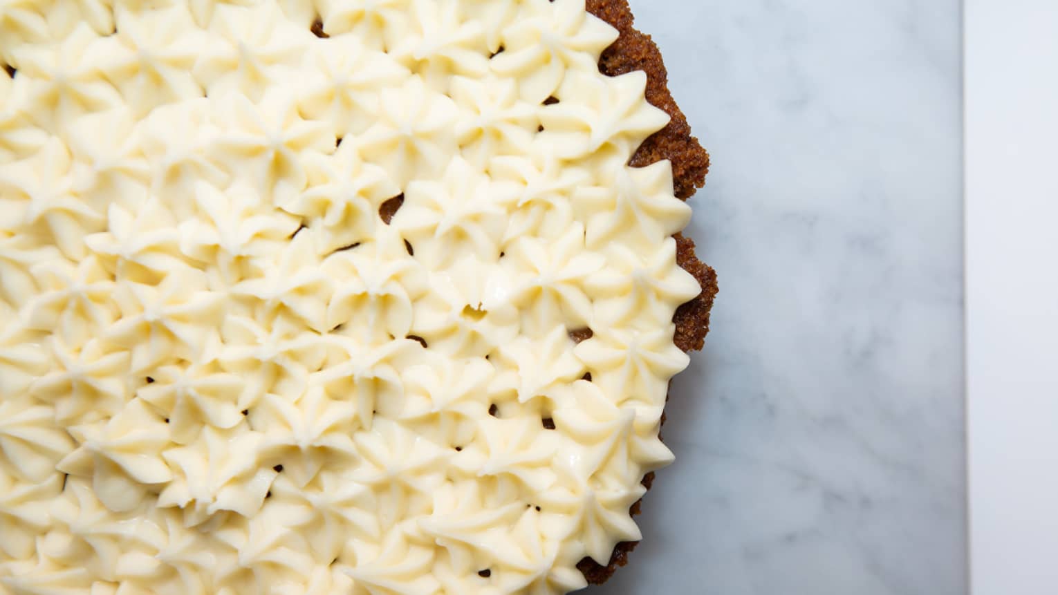The top of a pie covered in a white cream.