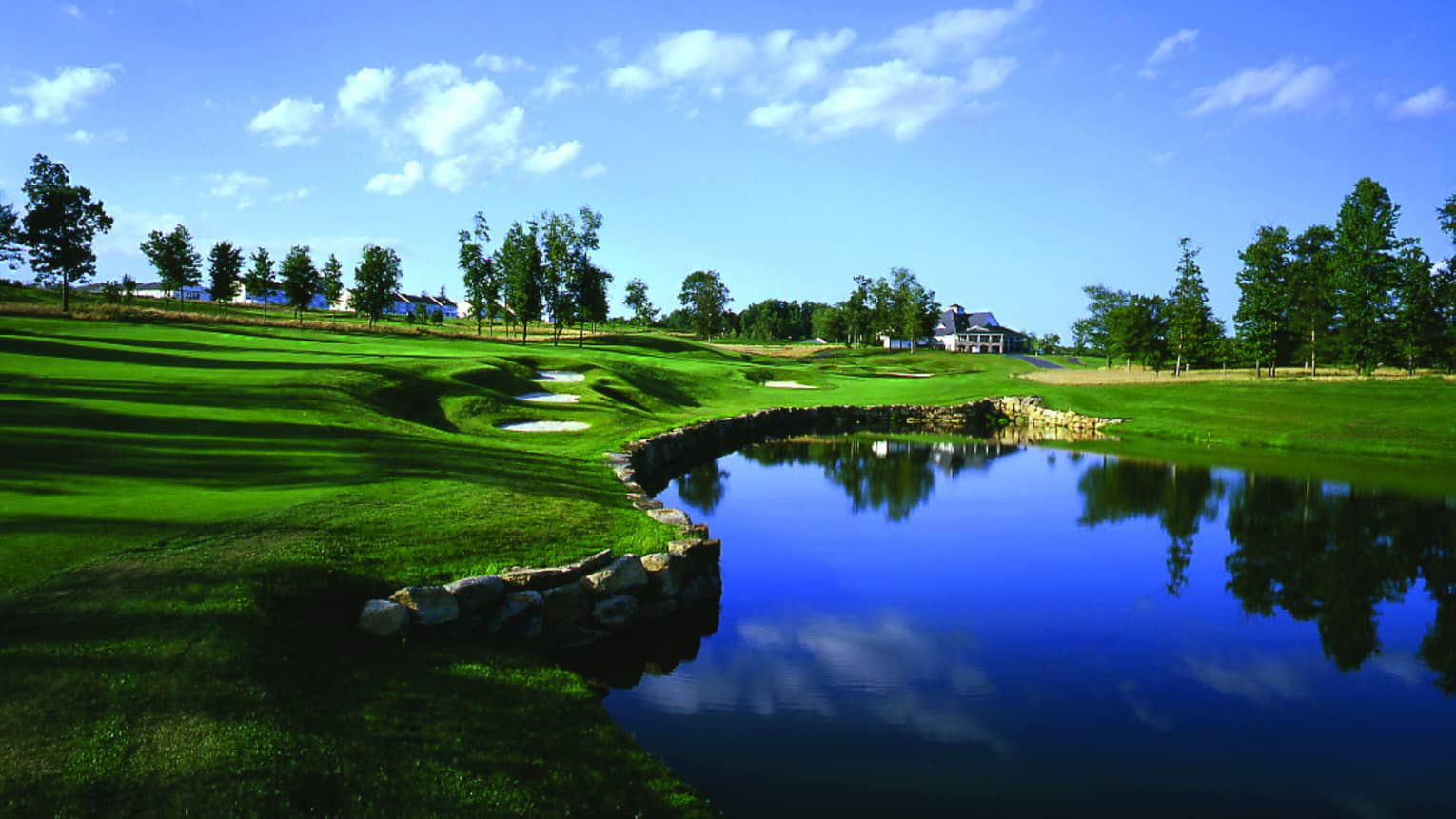 A golf course under a blue sky.