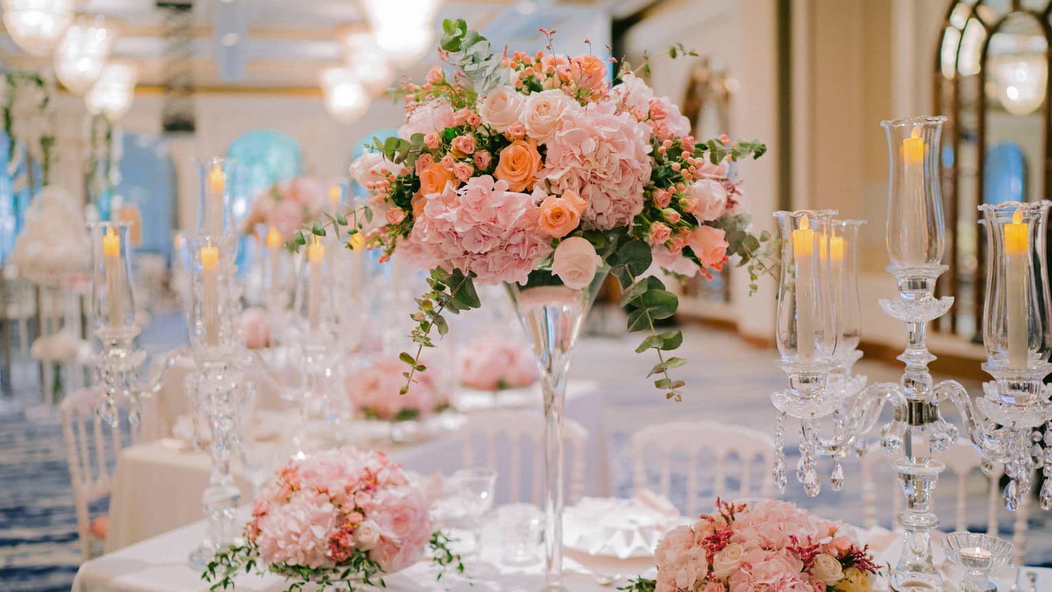Tall glass vase with pink flowers, floral arrangements on wedding banquet dining table