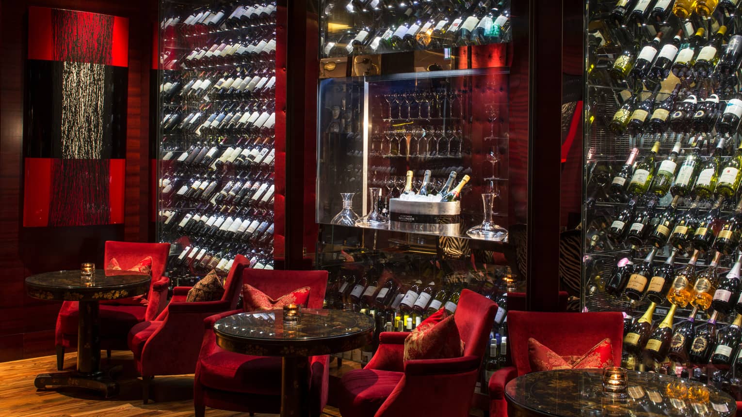 Amaranto Bar red velvet lounge chairs, large glass cellars with bottles, Champagne ice bucket