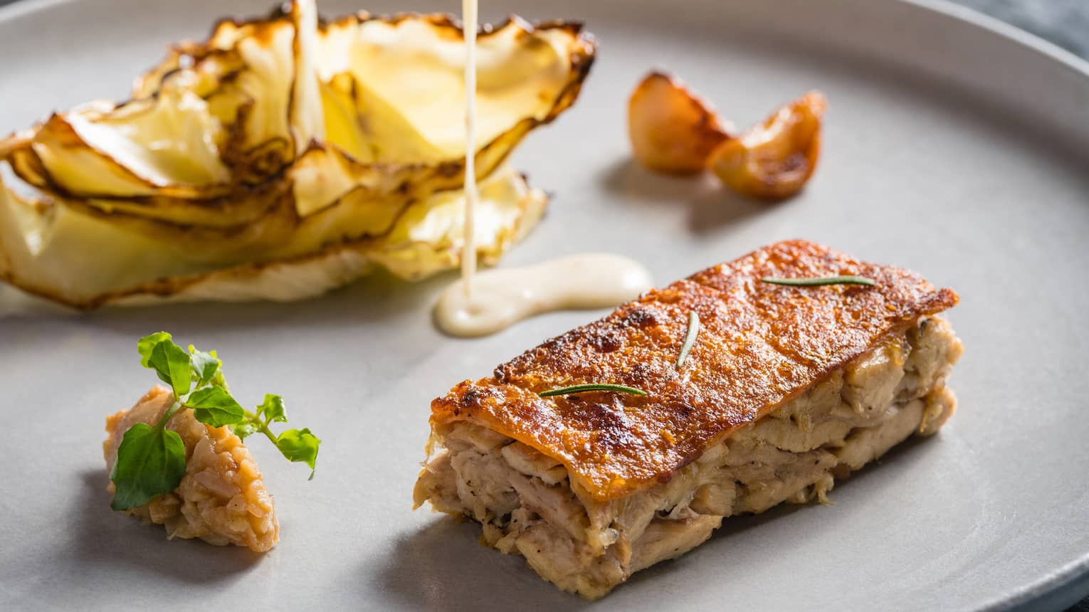 Crispy baby pig with snake fruit chutney, charred cabbage and mustard jus