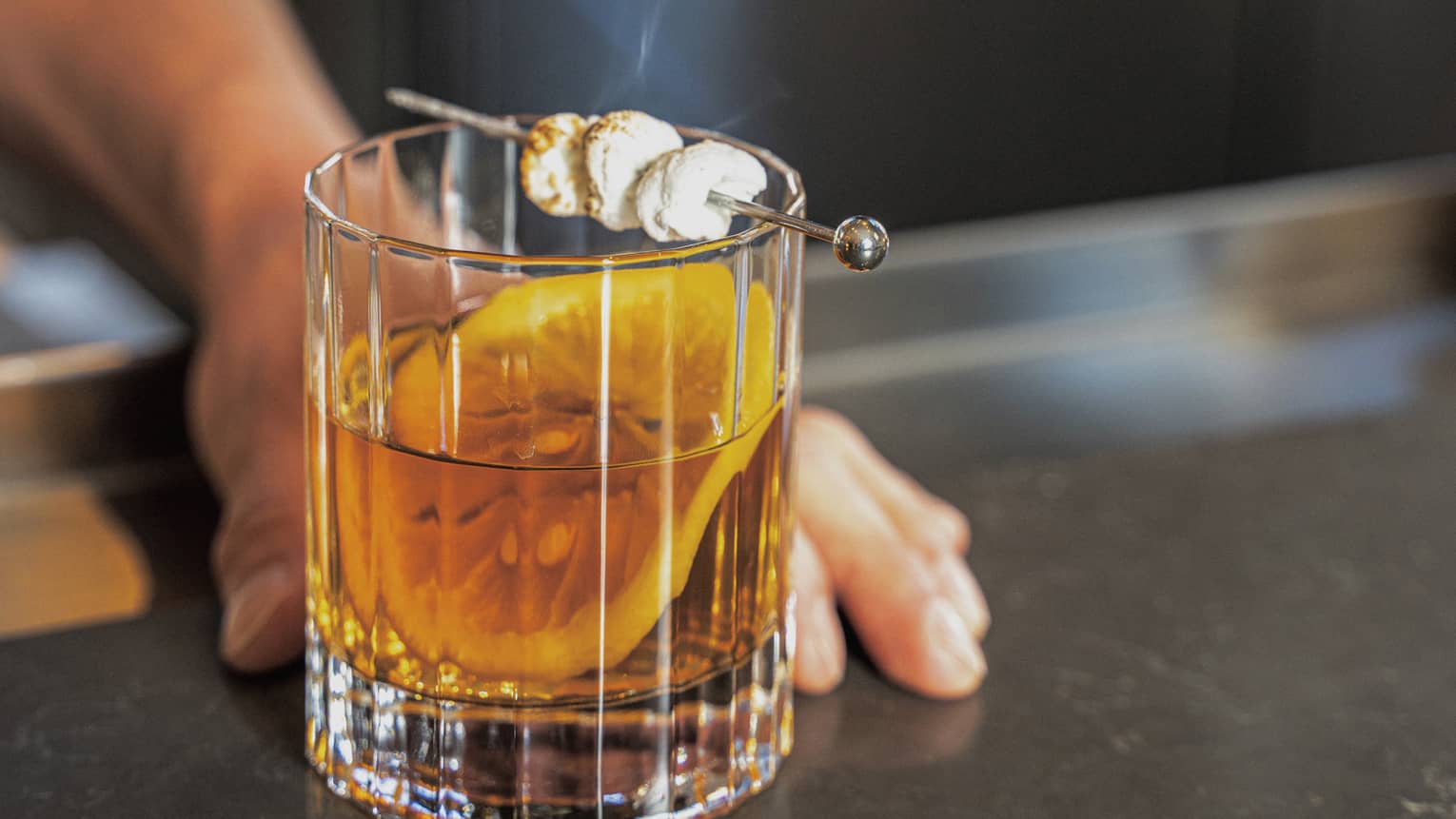 An orange cocktail with a torch near it.