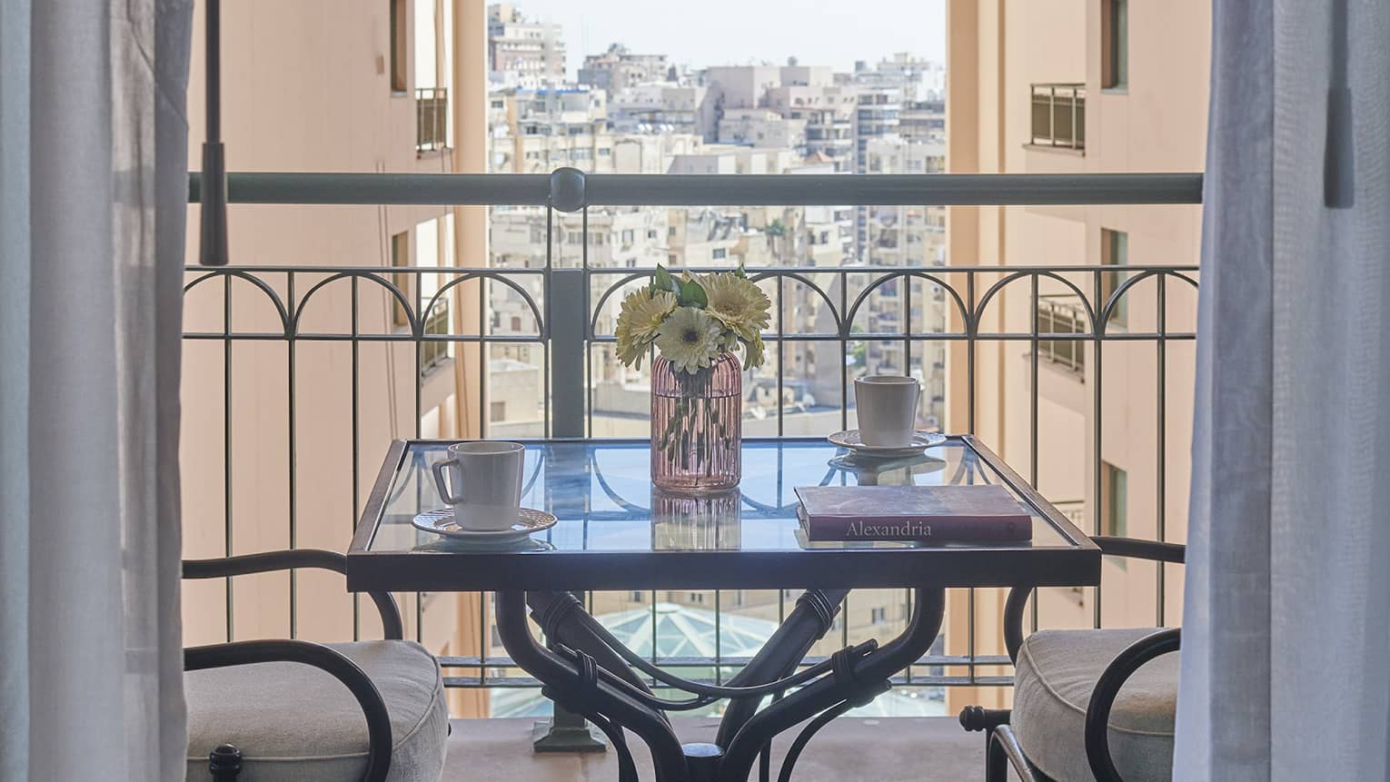 Veranda with two-seater square table, views of cityscape