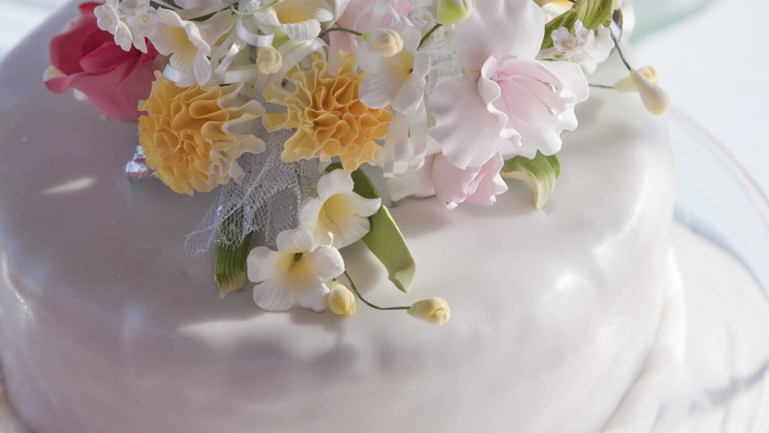 Small white wedding cake topped with fresh flower arrangement