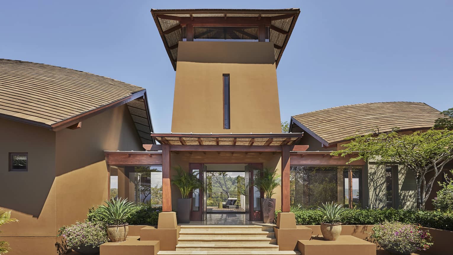 Front of the Casa del Mar Residence with portico, potted plants, vertical window