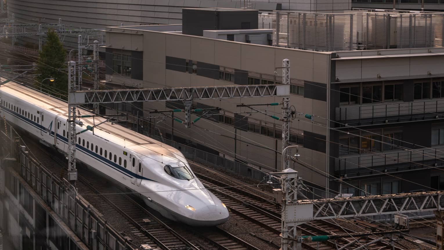 Shinkansen bullet train arrives at the station at sunset
