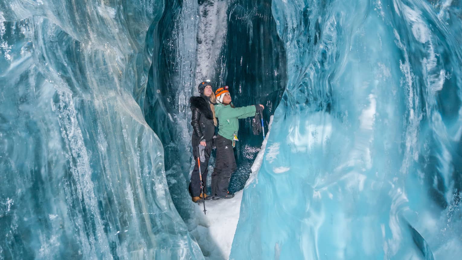 Two people walking in an ice cave in Whistler