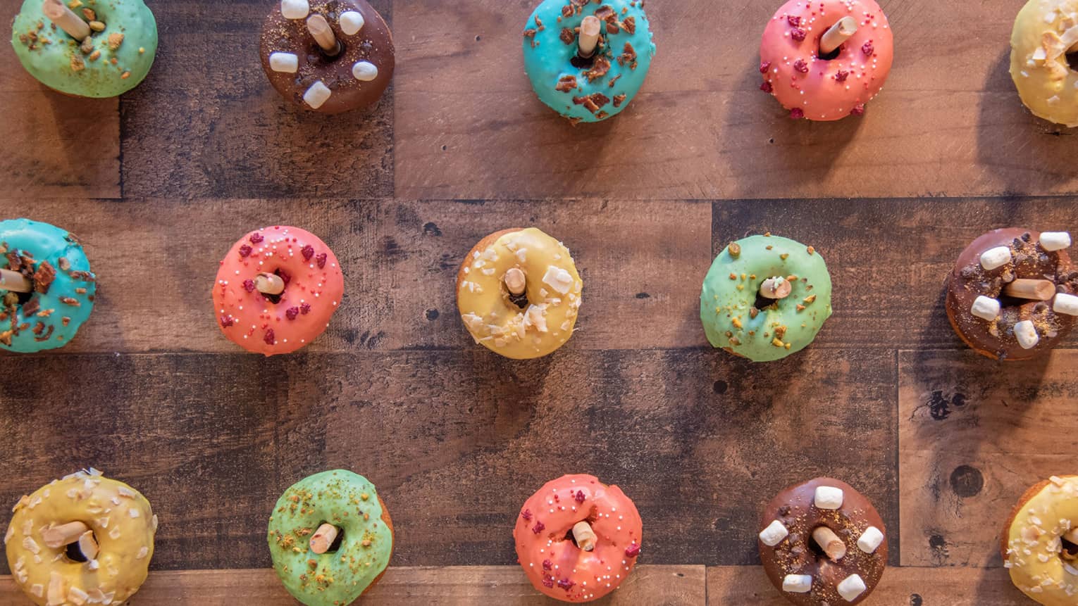 Pegboard display of colorfully decorated donuts.