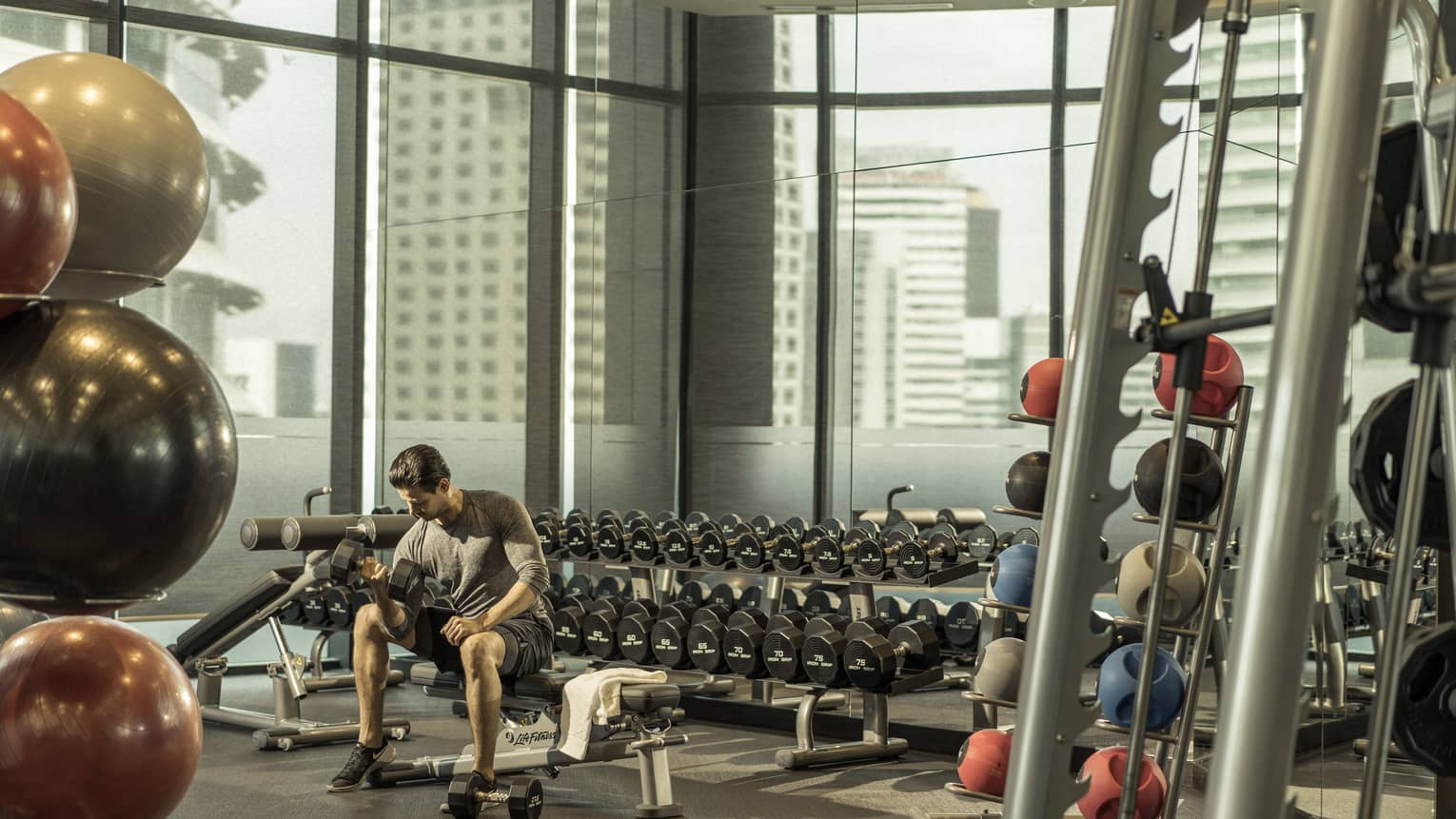 A man lifts weights in the gym at Four Seasons Hotel Kuala Lumpur
