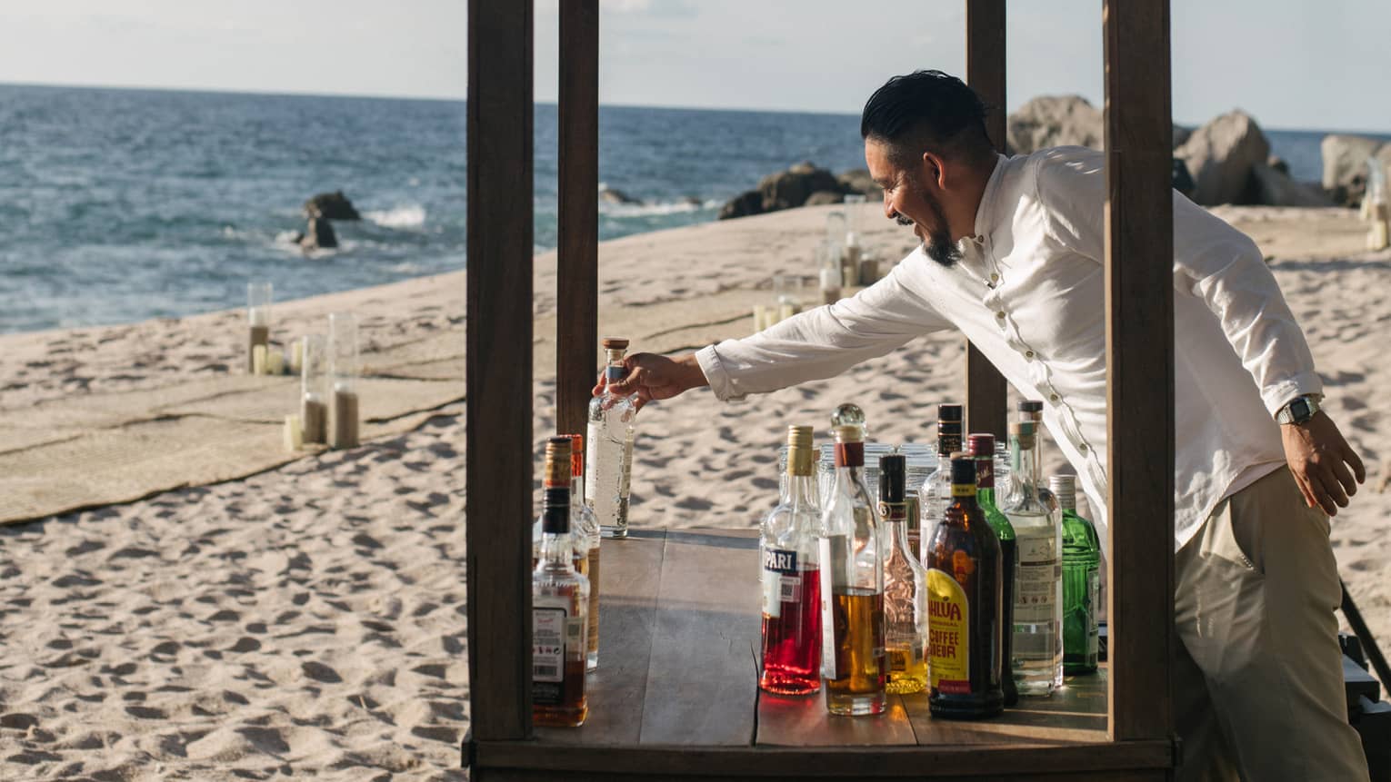 Man serving drinks in a booth on the beach