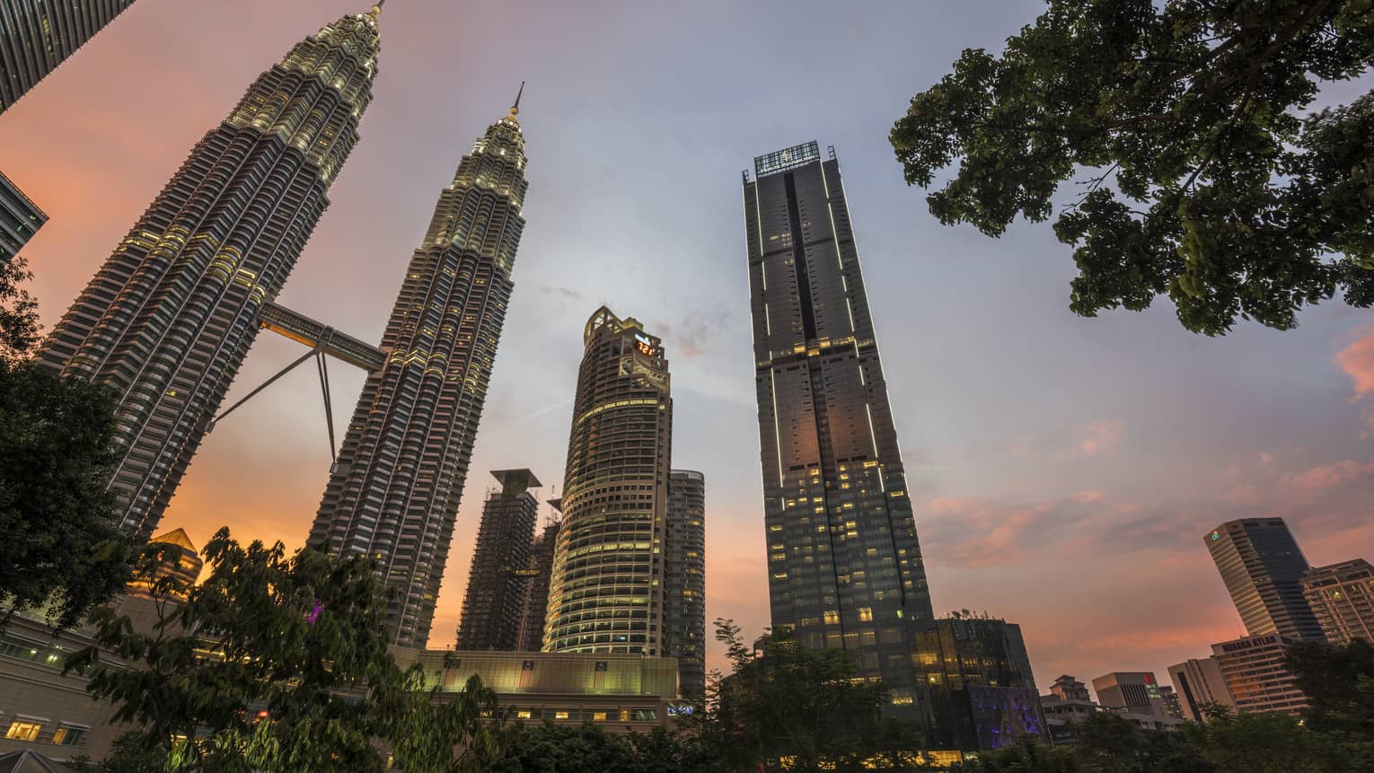 Four Seasons Hotel Kuala Lumpur against the sunset with the city skyline