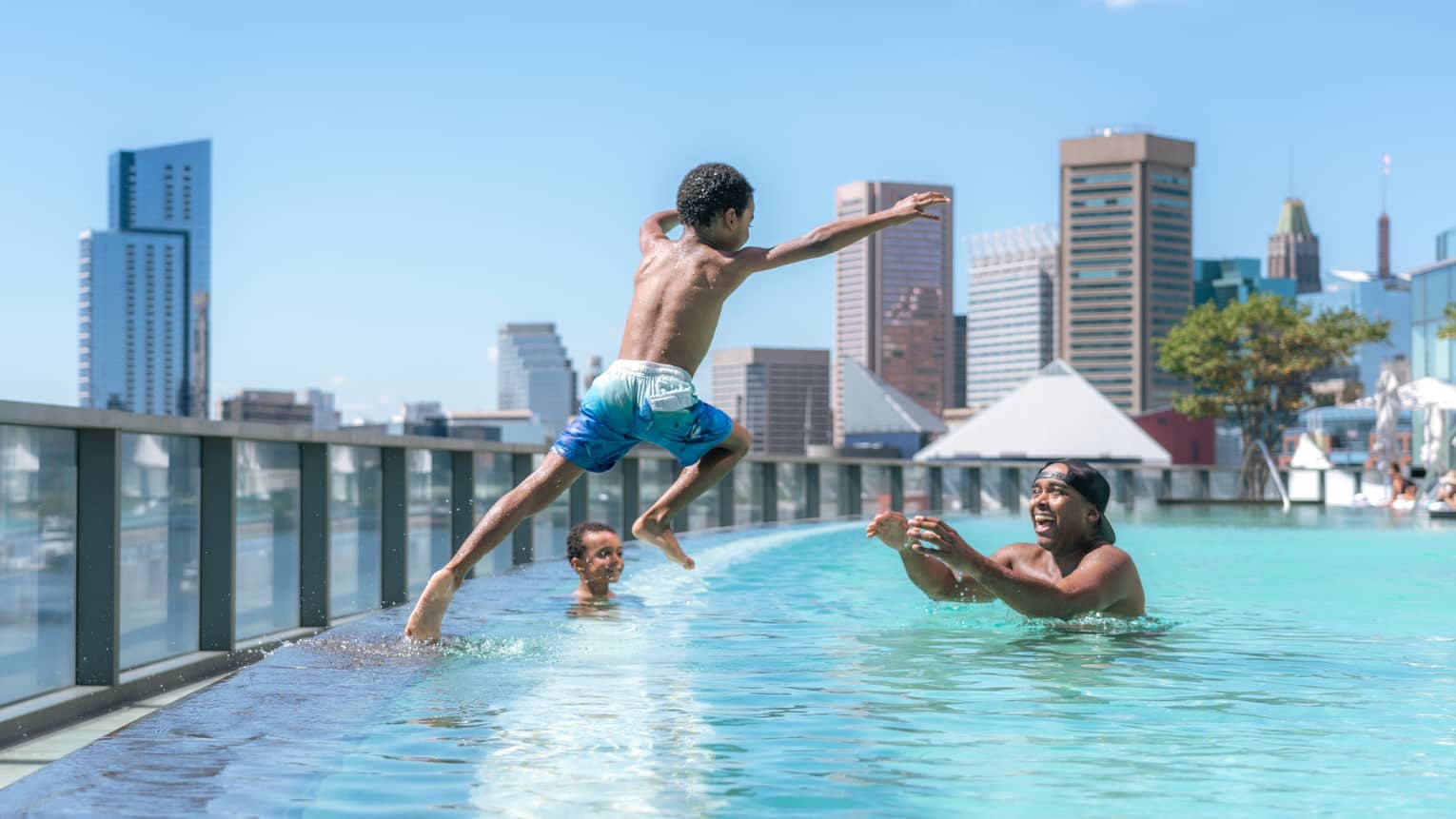 Child jumps into pool as parent waits in the water with open arms