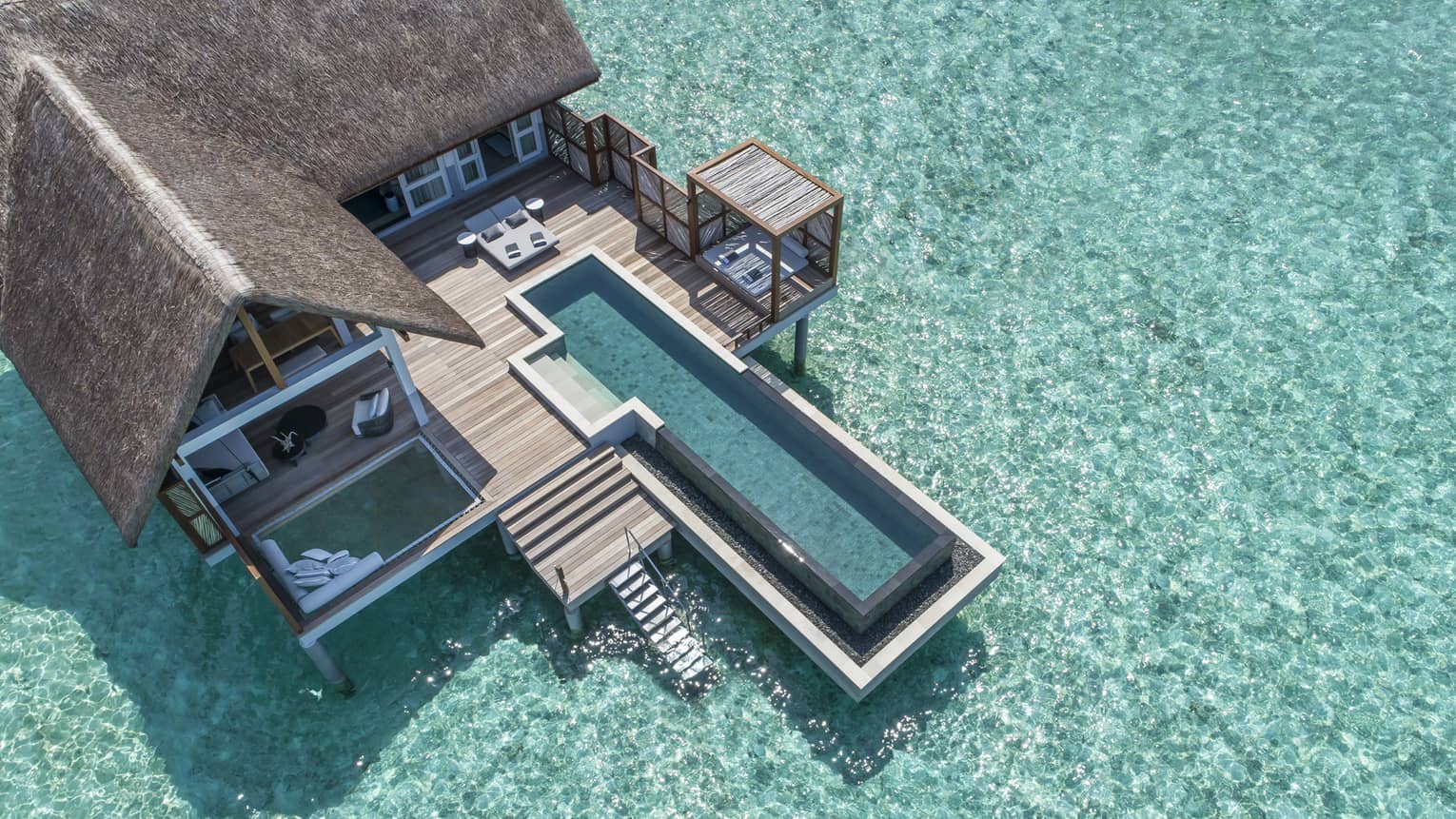 Aerial view of lure island villa with private pool and deck surrounded by crystal ocean