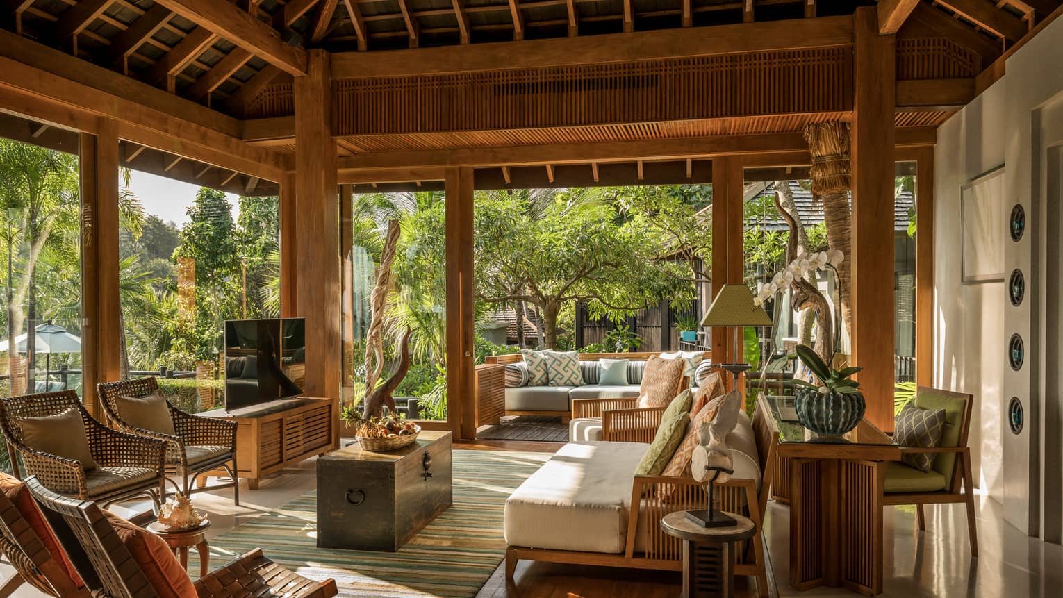 Wicker patio furniture, plush sofa under roof in open-air living room