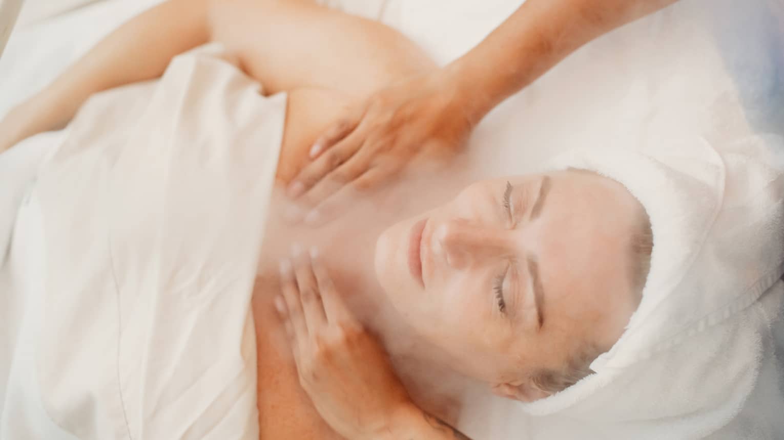 A woman receiving a facial massage in a spa.
