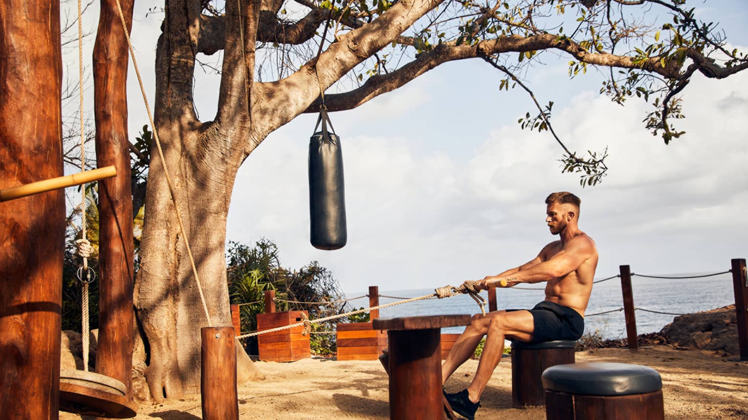 A man pulling on a rope to exercise outside.