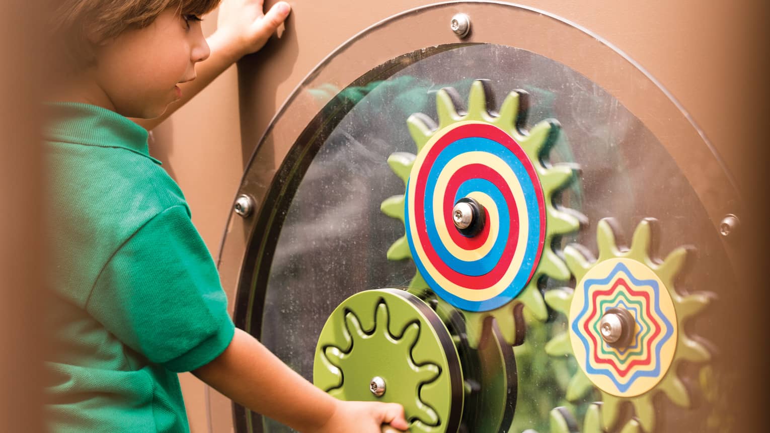 Young boy spins colourful wheel in Discovery Children's Museum