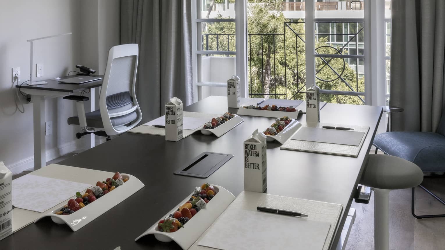 A large table with drinks and office supplies on it.