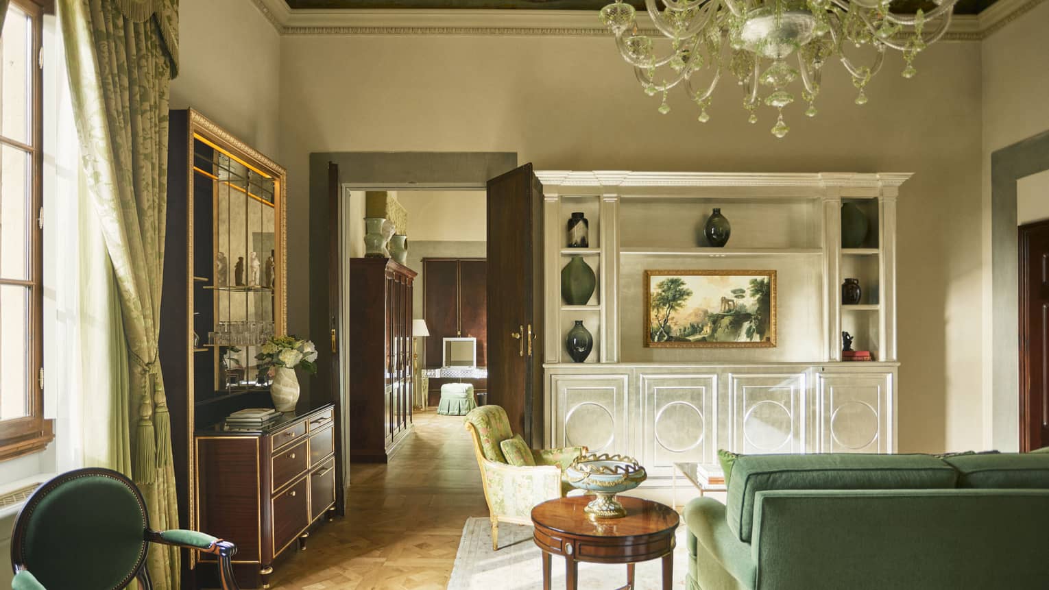 Renaissance Suite living room with green sofa, frescoed ceiling and chandelier at Four Seasons Hotel Florence