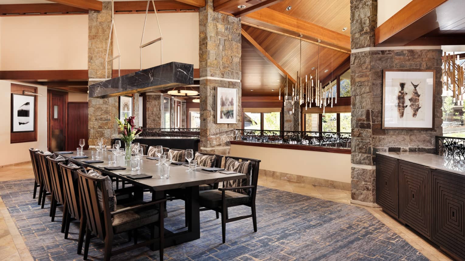 Elegant restaurant dining table with fresh-cut flowers and ten seats on the upper level of Westbank Grill