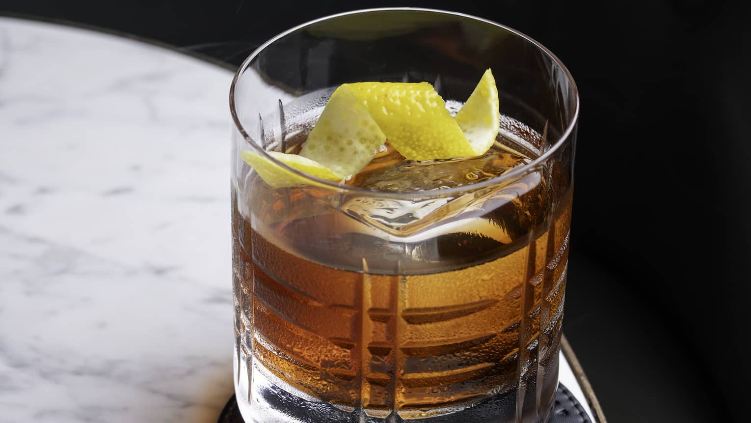 Old Fashioned cocktail on a marble table