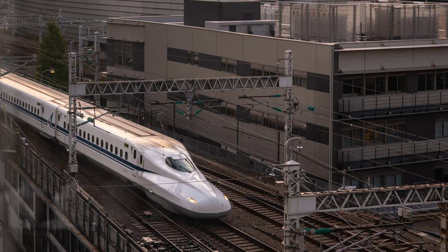 Shinkansen bullet train arrives at the station at sunset