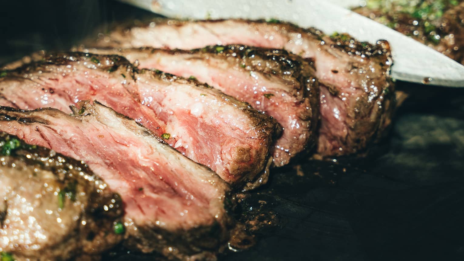 Flank steak being sliced by a chef