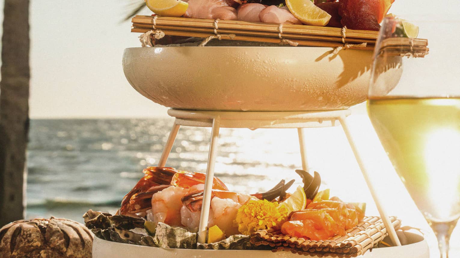 A tiered dish with different seafood on a patio table