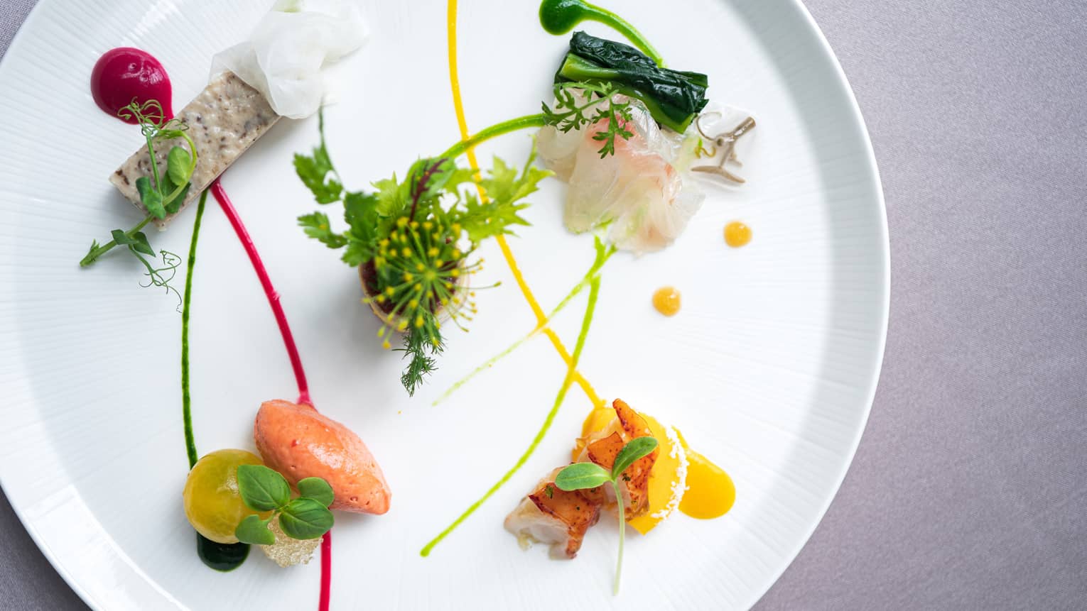 Small appetizers arranged on plate with artistic garnish