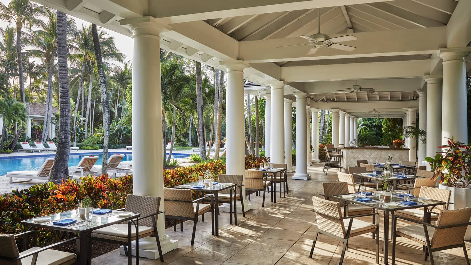 Versailles Terrace restaurant patio, tables under white pillars, ceiling, near swimming pool