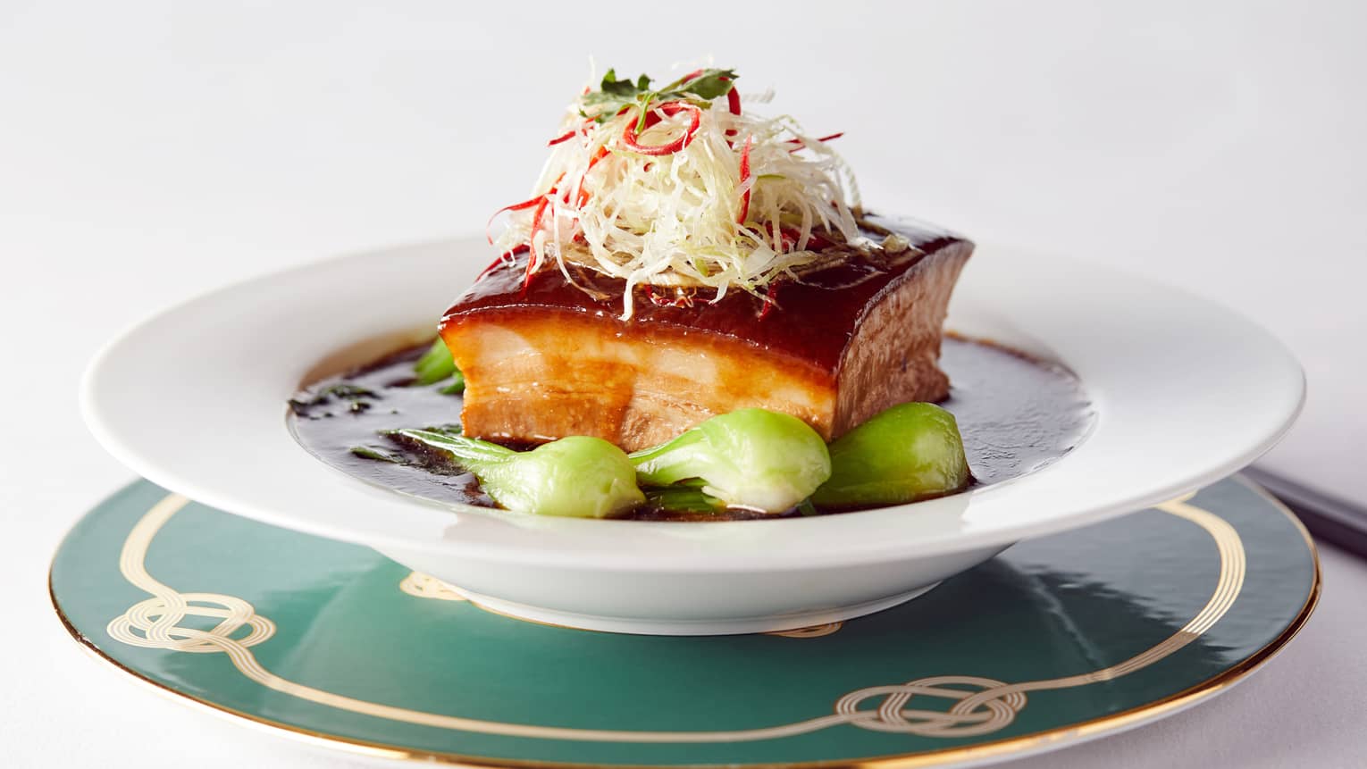Korean cuisine in white bowl with greens and garnish 