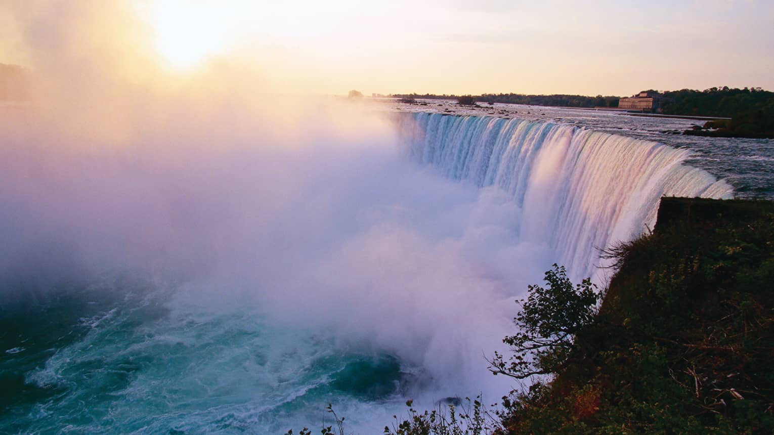 Mist rising from Niagara Falls waterfall at sunrise 