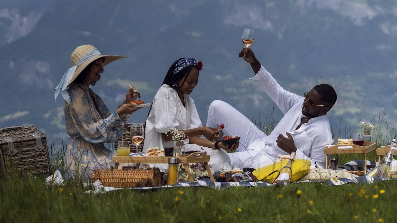 Three people enjoy gourmet picnic with ros� in French Alps