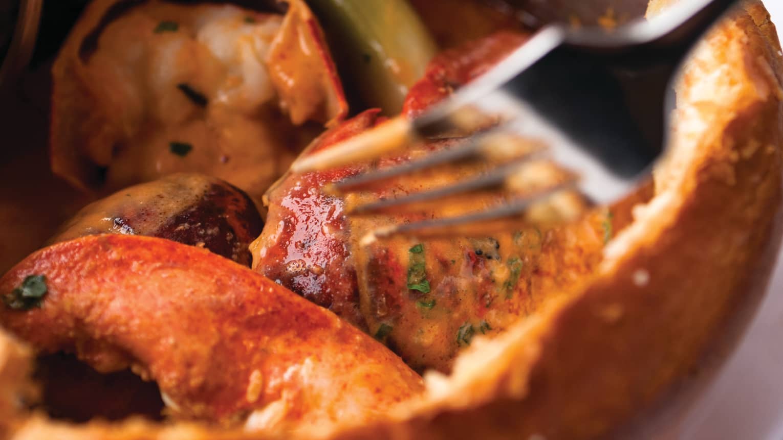 Close-up of Bourbon Restaurant's signature lobster pie, red lobster chunks in crust