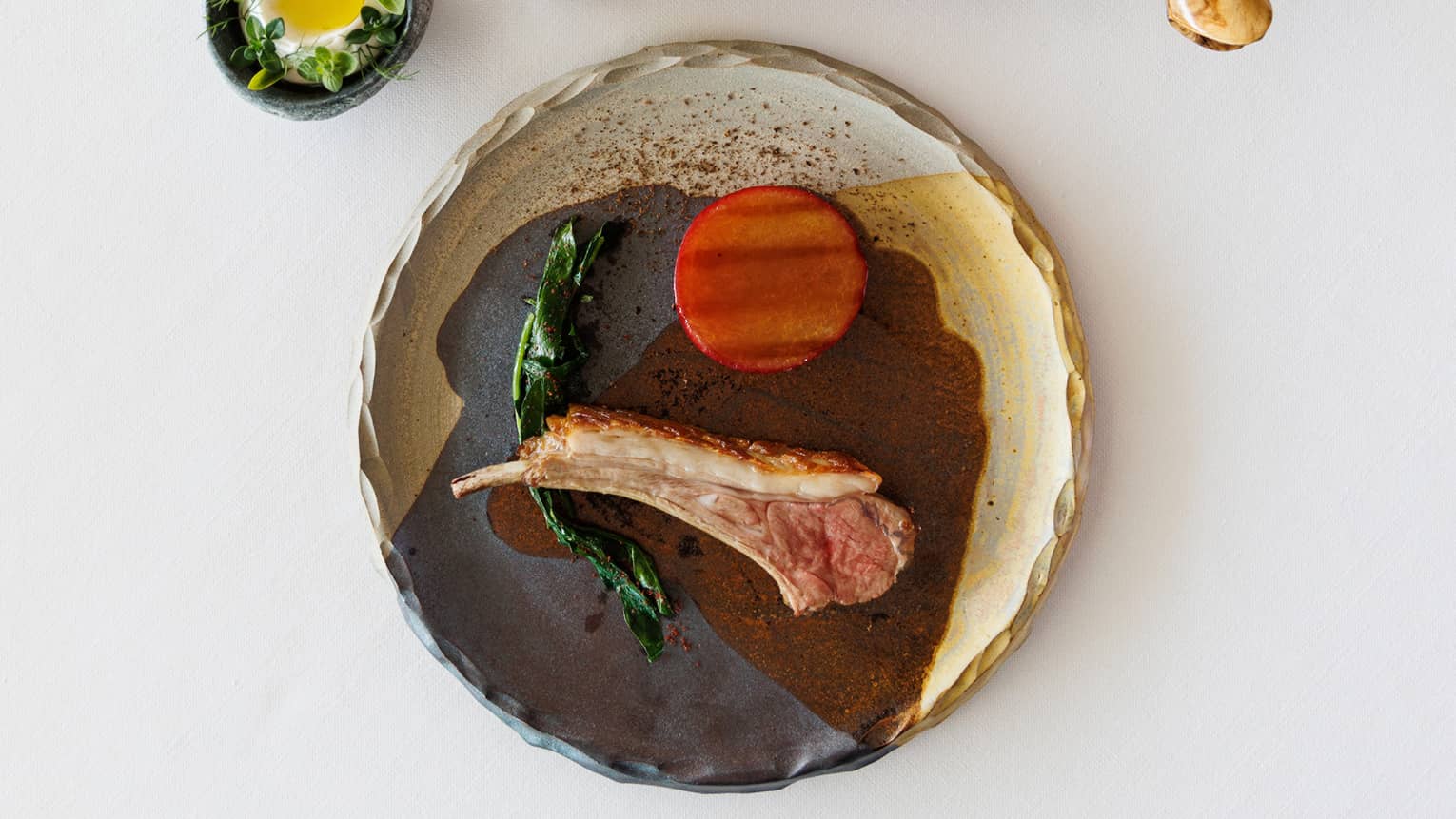 Lamb and greens on a plate and tray.
