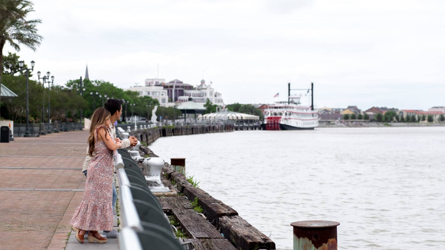 A woman and man looking out a river.