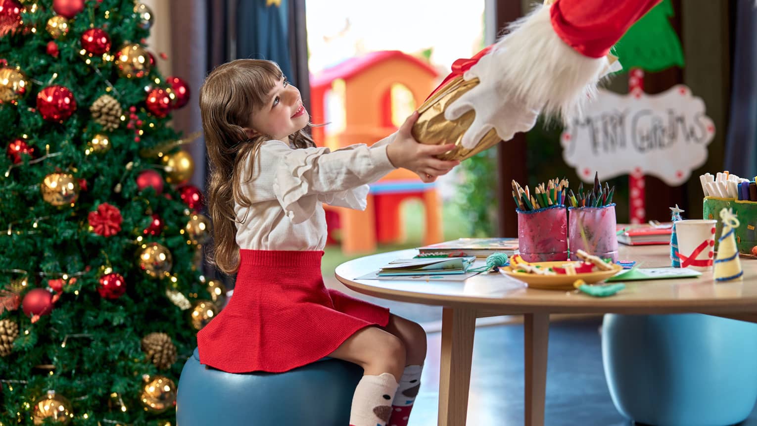 Child receiving a gift from Santa Claus during a Christmas experience