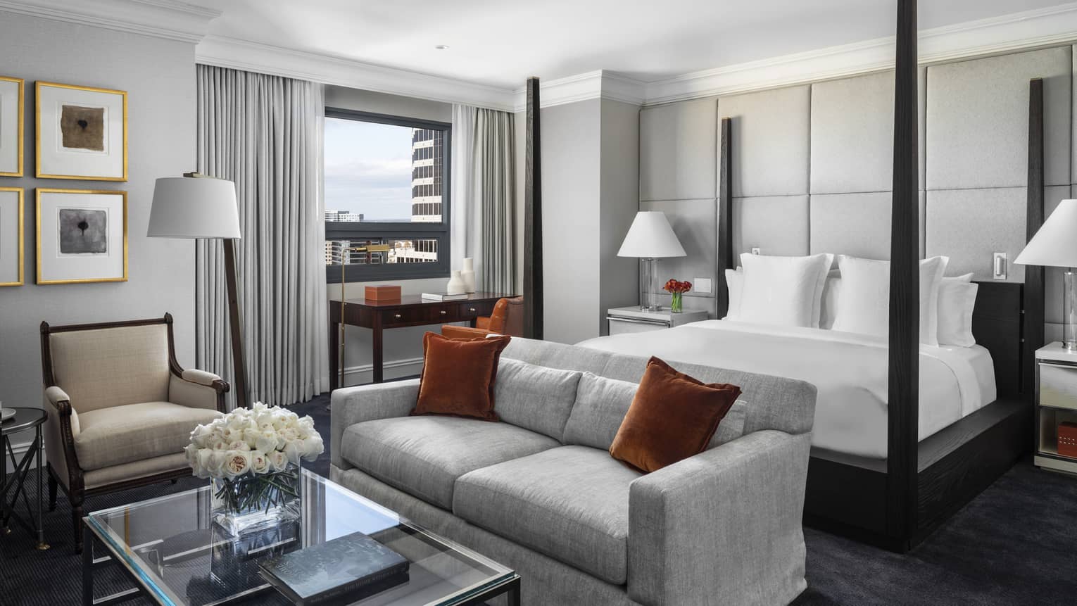 Presidential Suite poster bed against white padded wall, behind seating area 