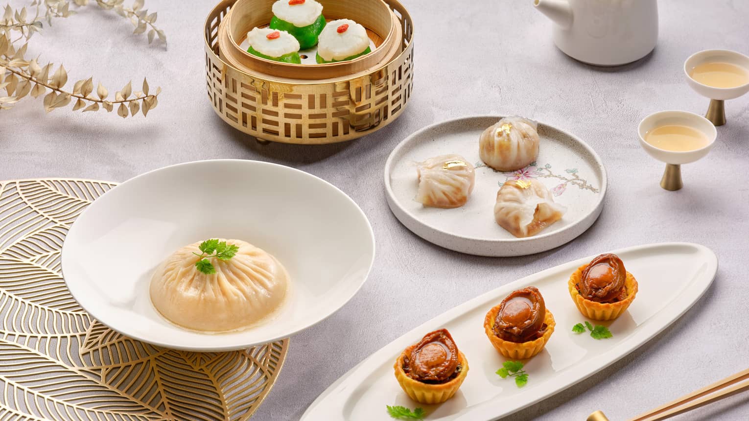 ,Several small savory food dishes served with a pot of tea