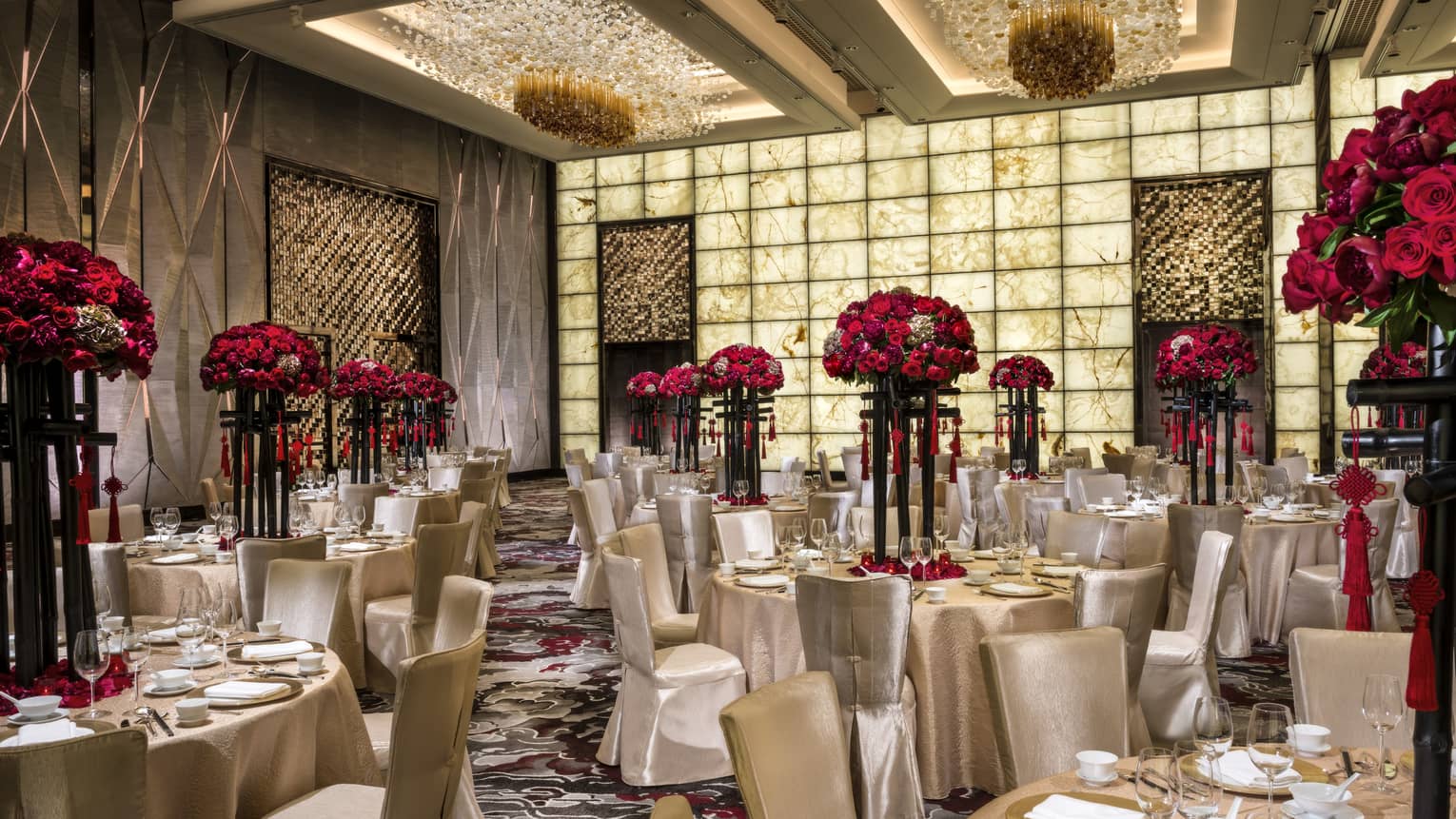 Grand Ballroom banquet tables and chairs with silk linens, red flowers in tall vases 