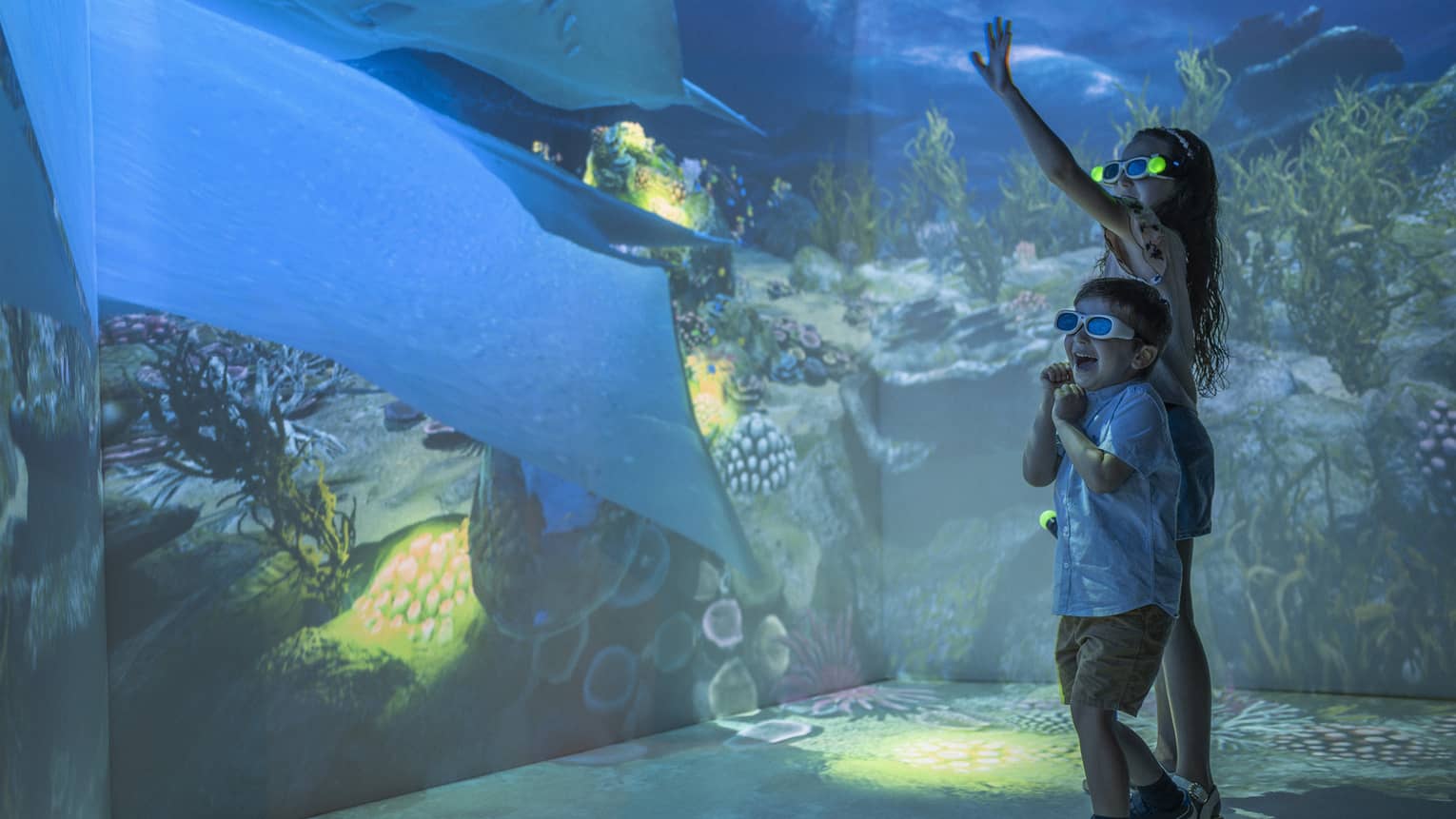 Young girl and boy wearing 3D glasses in the Hologram Room at the Marine Discovery Centre
