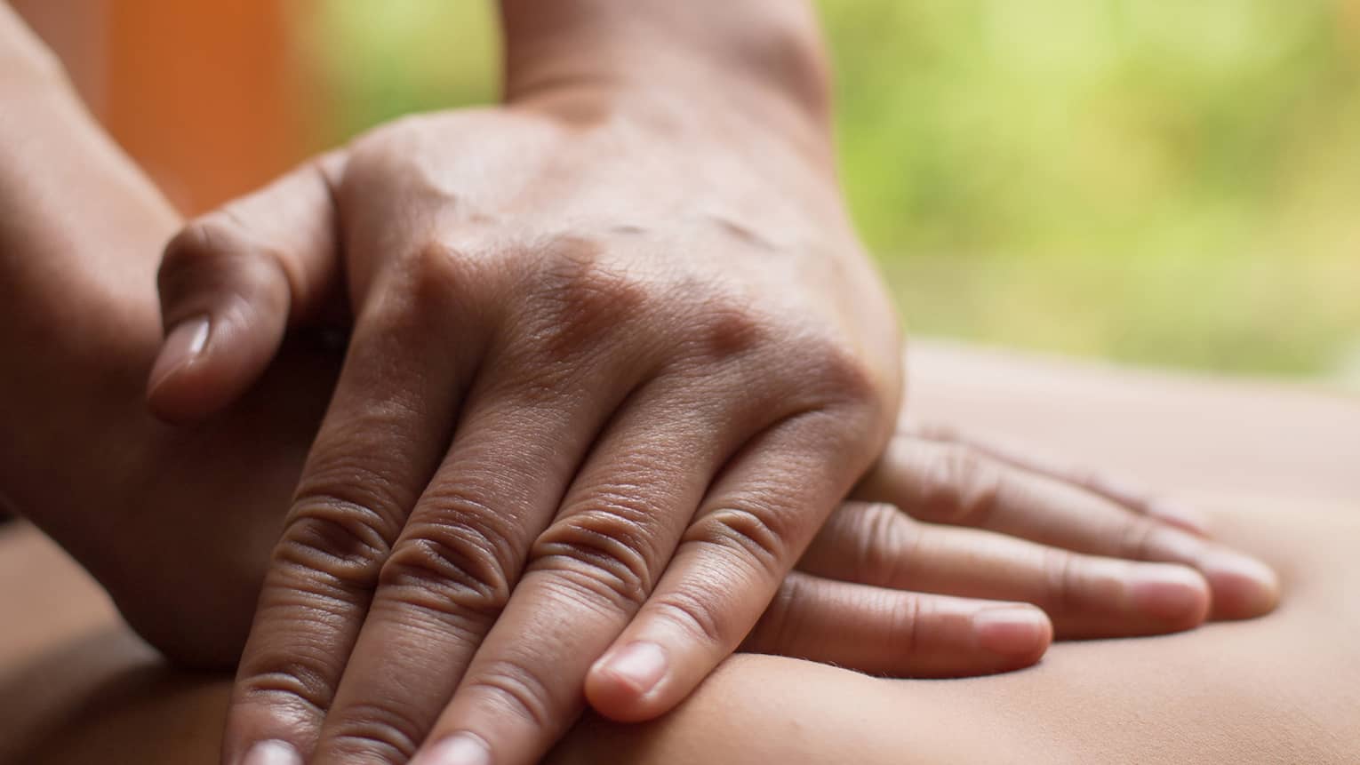 Close up of hands massaging a back