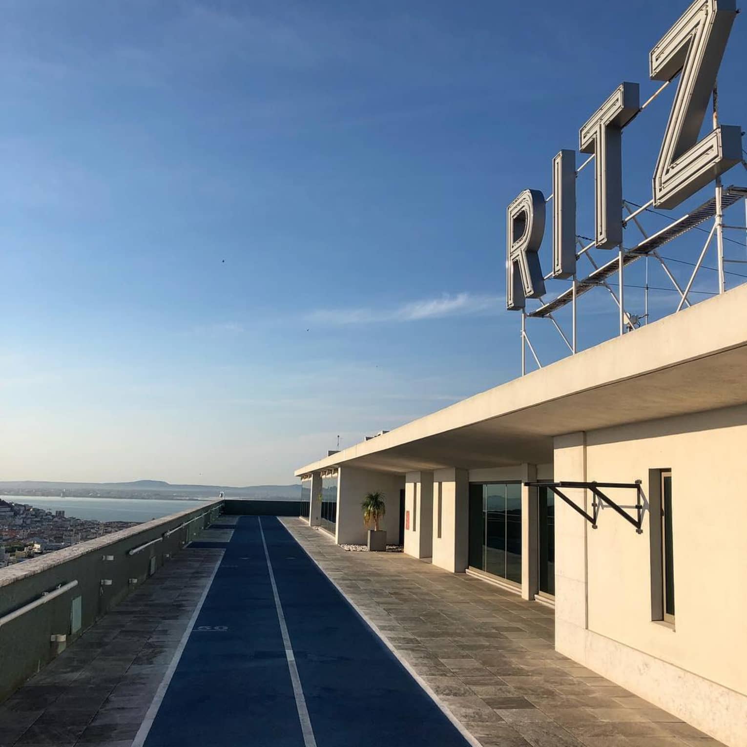 RITZ sign over building, path against blue sky