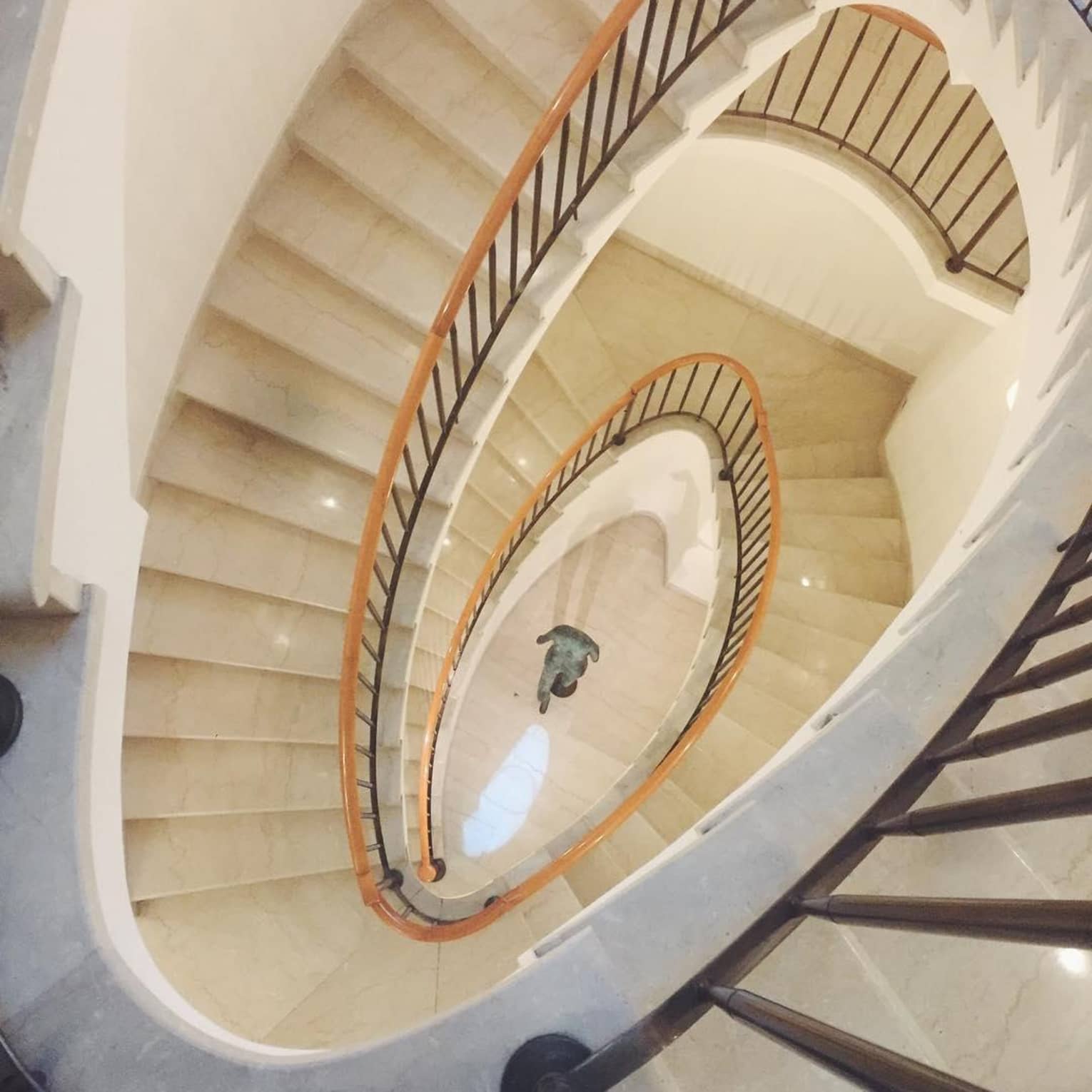 View down white marble spiral staircase 