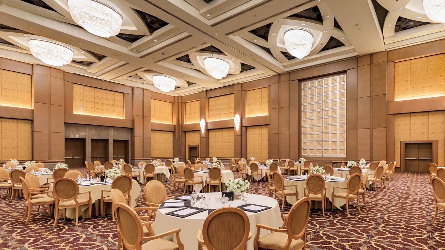 Banquet tables set for an event in a grand hotel ballroom