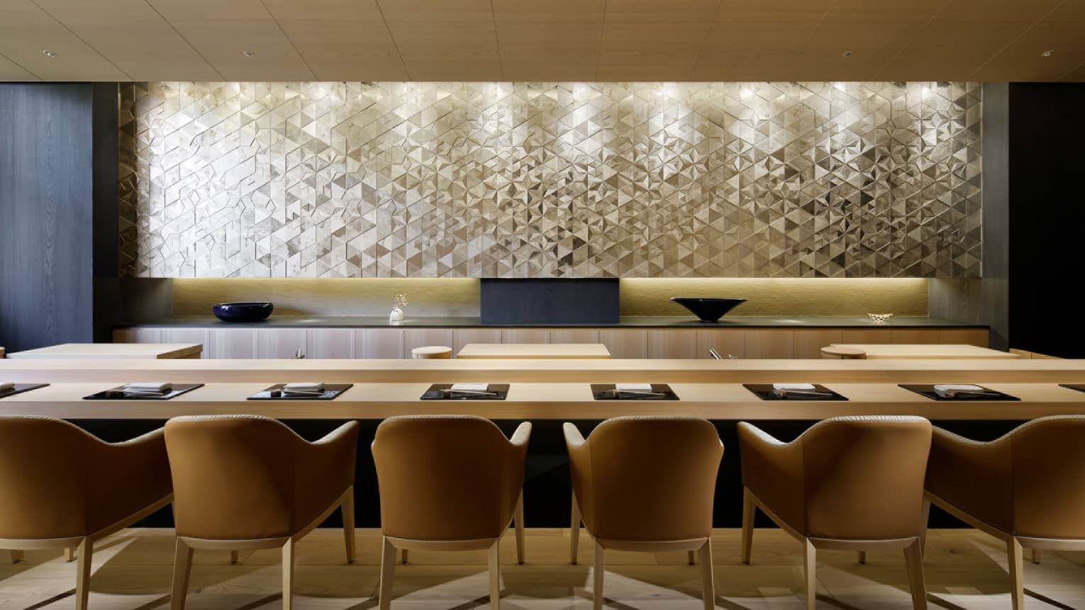 Sushi Wakon large chairs line light wood bar under silver tile wall