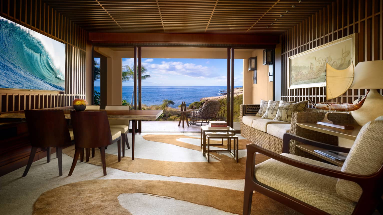 Teak panel wall with TV, wood dining table across from wicker sofa, swirl-patterned carpet