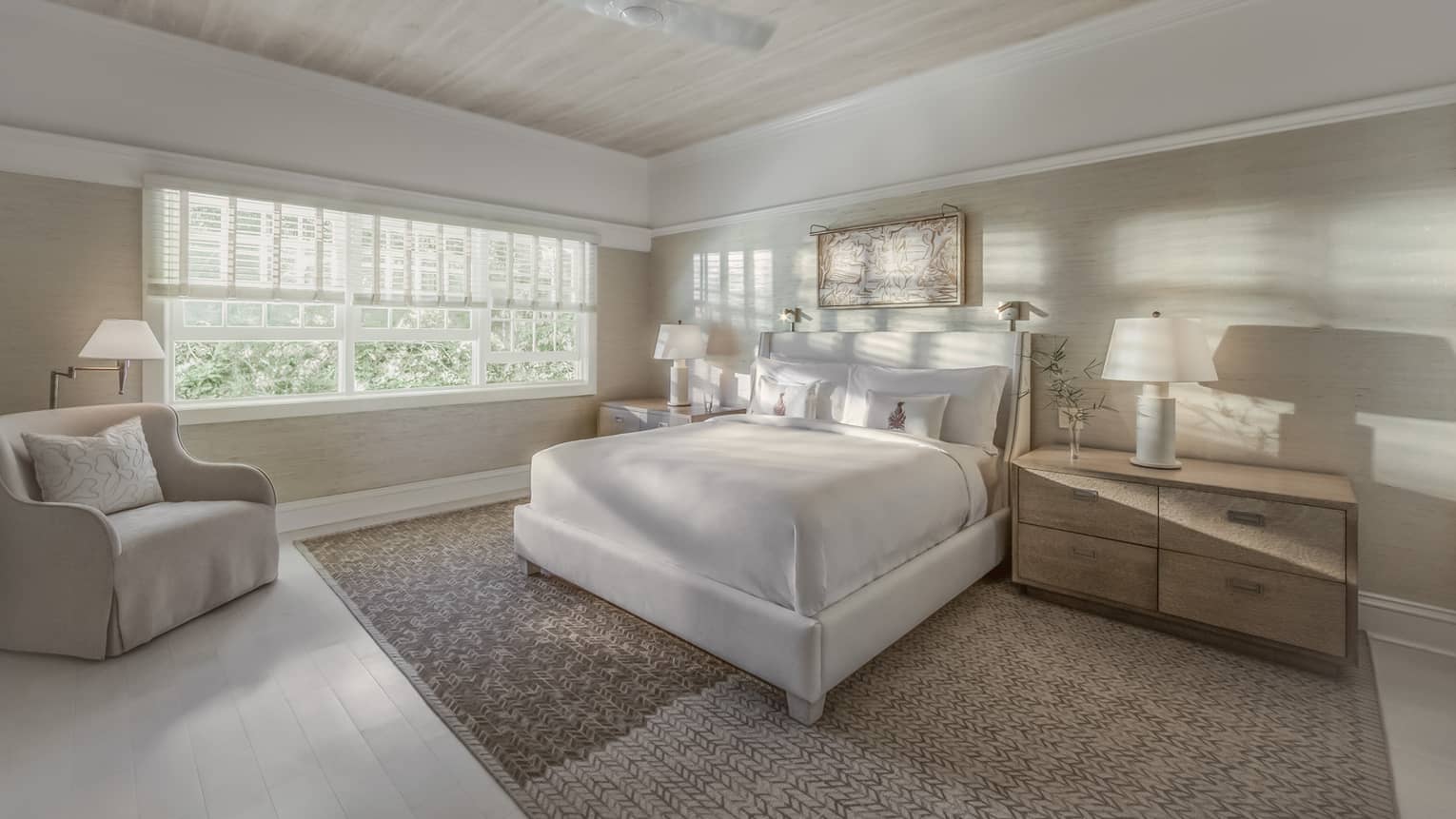 Sunlight and shadows shine through the window of a master suite bedroom